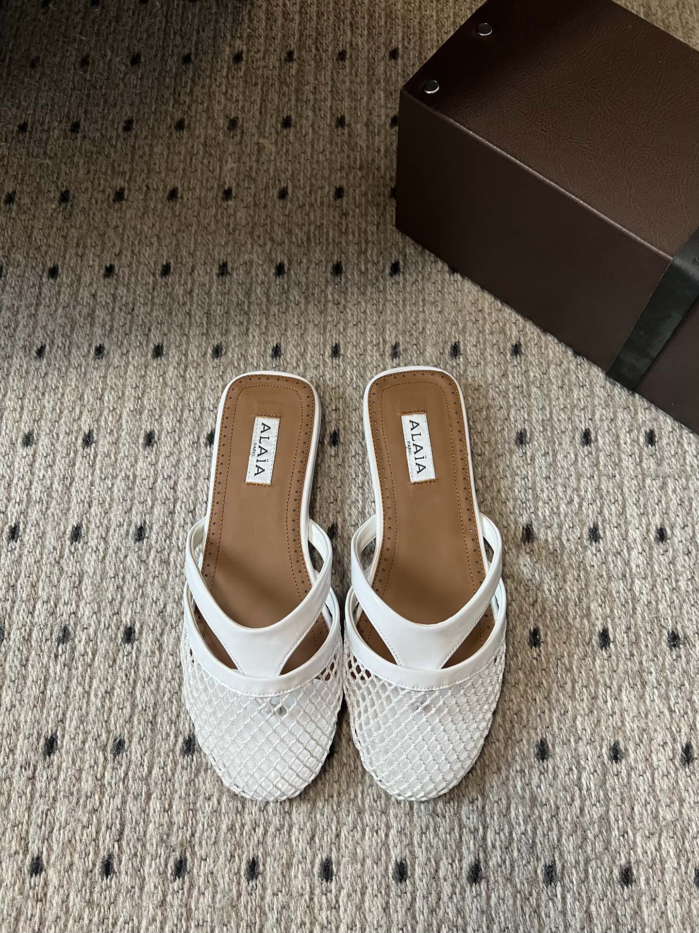 Alaia 25 Mules Planos de Red Infradito de Piel de Cordero Blanca 303706